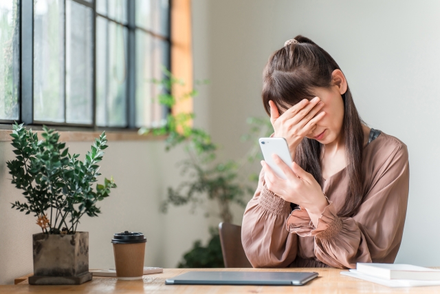 SNSをみて悩む女性